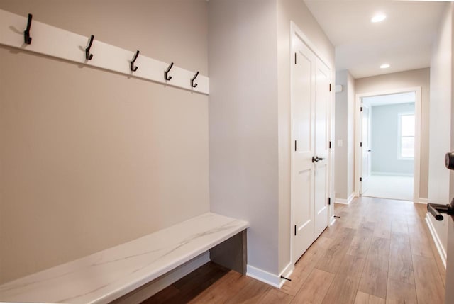 mudroom with light wood finished floors, recessed lighting, and baseboards