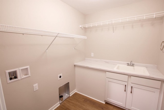 clothes washing area with hookup for an electric dryer, washer hookup, a sink, cabinet space, and dark wood finished floors