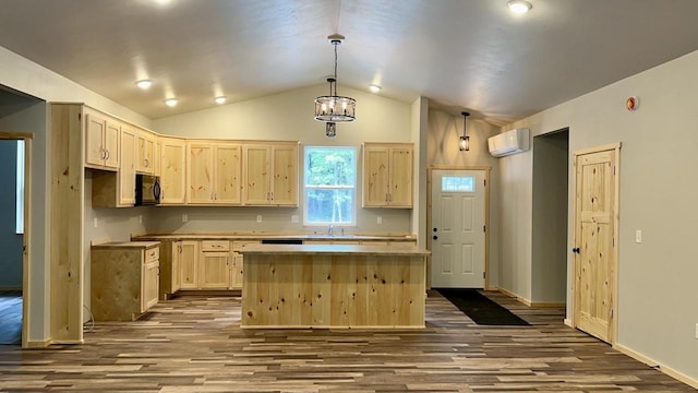 kitchen with light brown cabinetry, an AC wall unit, decorative light fixtures, vaulted ceiling, and a kitchen island