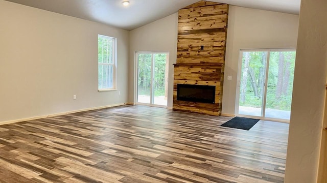 unfurnished living room featuring a large fireplace, high vaulted ceiling, and wood-type flooring