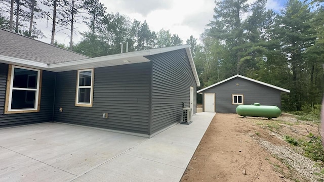 view of home's exterior with a patio area and an outdoor structure