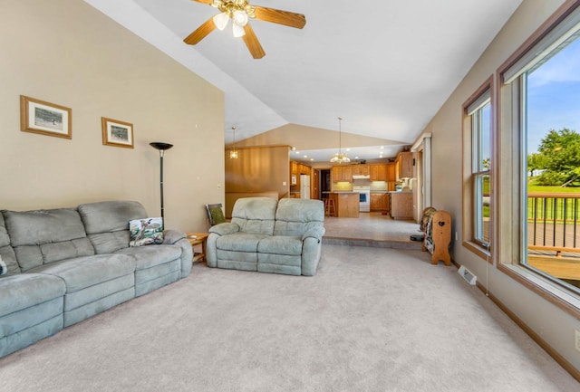 living room featuring lofted ceiling, ceiling fan with notable chandelier, and light colored carpet