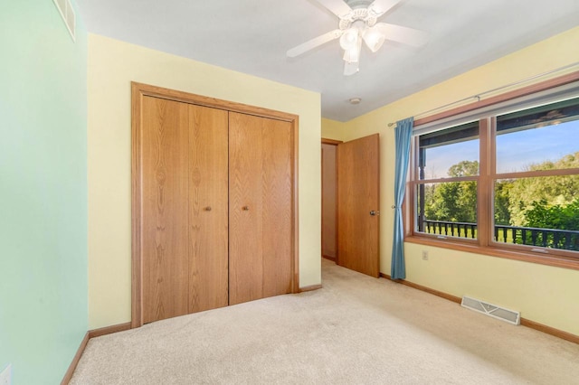 unfurnished bedroom featuring light colored carpet, ceiling fan, and a closet