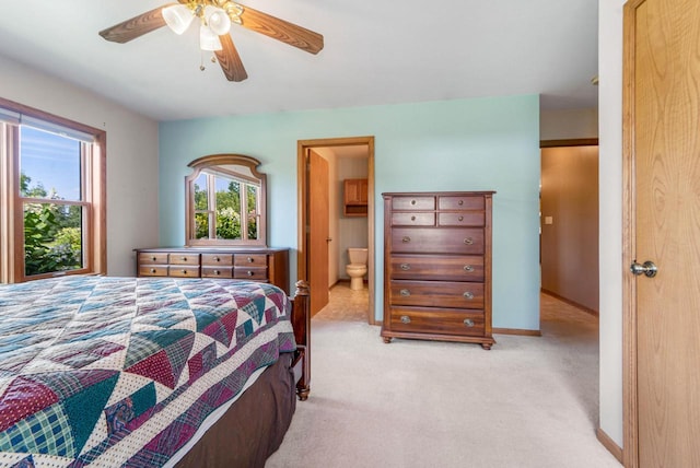 carpeted bedroom featuring ceiling fan and ensuite bath