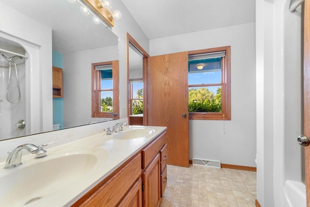 bathroom featuring vanity, walk in shower, and toilet