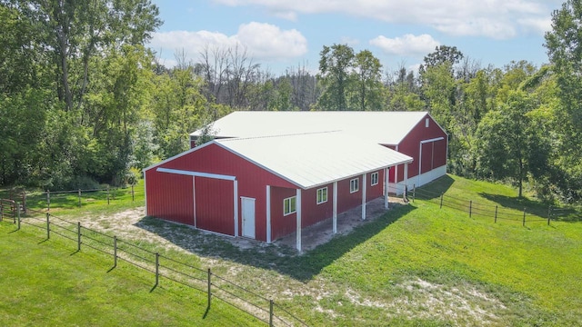 view of outbuilding featuring a rural view and a lawn