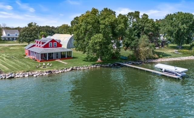 view of dock featuring a lawn and a water view