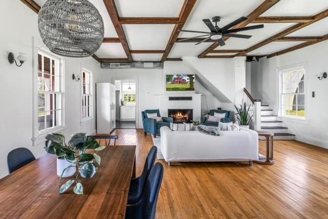 living room featuring ceiling fan, coffered ceiling, hardwood / wood-style floors, and beam ceiling