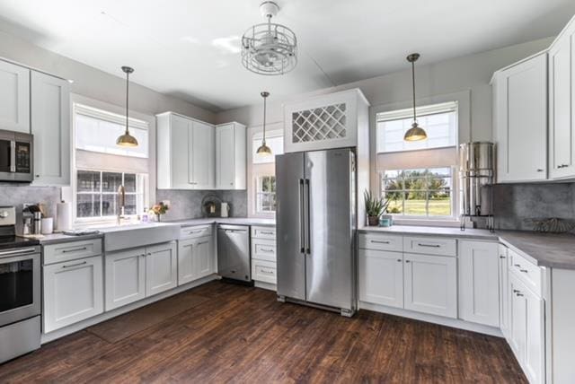 kitchen with backsplash, stainless steel appliances, and decorative light fixtures