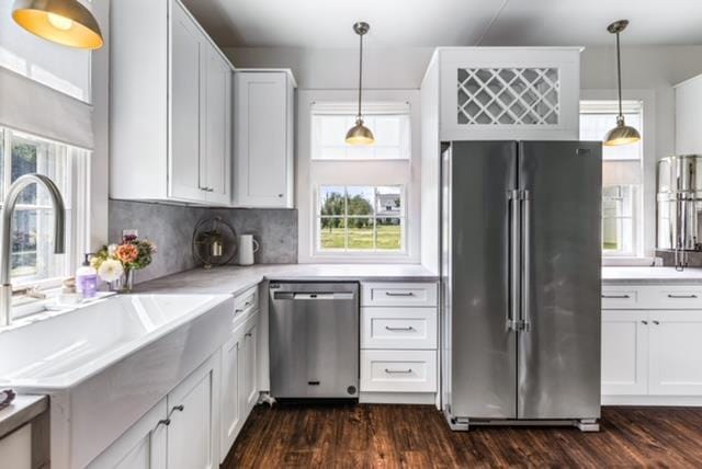 kitchen with backsplash, stainless steel appliances, dark wood-type flooring, and white cabinets