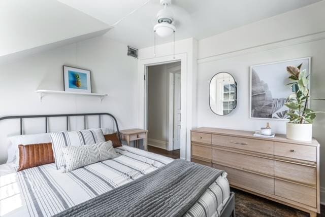 bedroom with ceiling fan, dark hardwood / wood-style floors, and vaulted ceiling