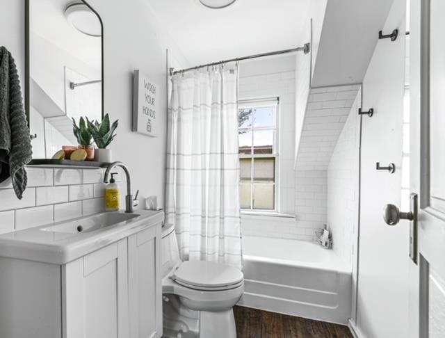 full bathroom with hardwood / wood-style floors, vanity, shower / bathtub combination with curtain, tile walls, and toilet