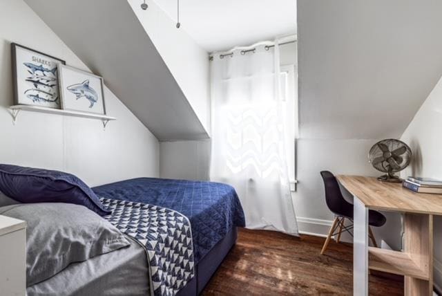 bedroom featuring lofted ceiling and dark hardwood / wood-style floors