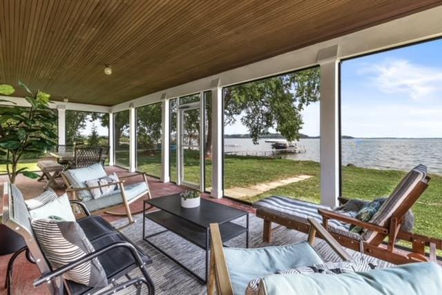 sunroom featuring a healthy amount of sunlight and a water view