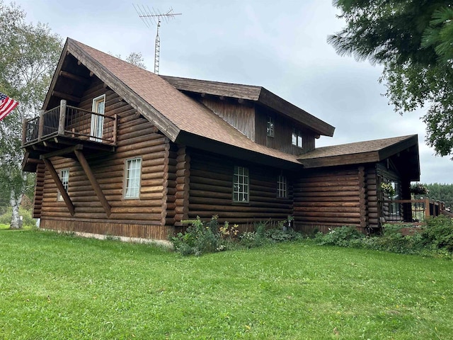 W6769 County Road D, Sheldon, WI 54766 - view of side of home featuring log exterior, a yard, a balcony, and a shingled roof