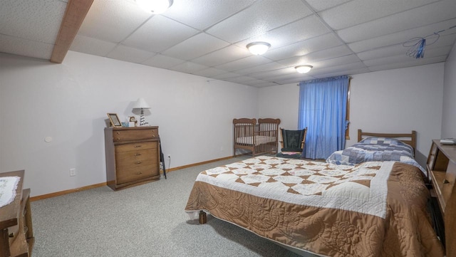 bedroom with a paneled ceiling and carpet flooring