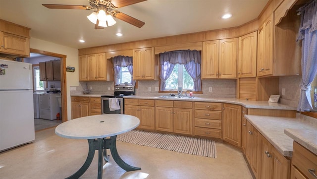 kitchen featuring stainless steel range with electric stovetop, white fridge, tasteful backsplash, washer and dryer, and ceiling fan