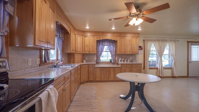 kitchen featuring ceiling fan, range with electric stovetop, sink, and decorative backsplash