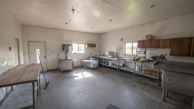 misc room with a healthy amount of sunlight and concrete floors