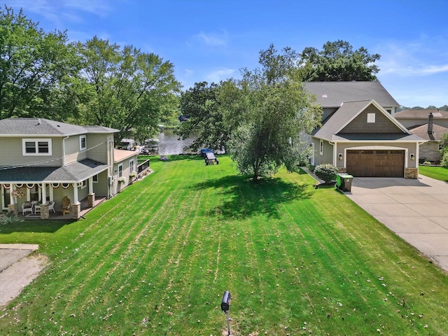 view of front of house featuring covered porch, a garage, and a front lawn