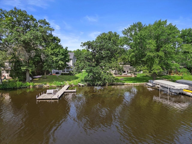 view of dock with a yard and a water view