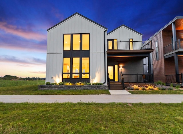 view of front of property featuring a balcony and a lawn