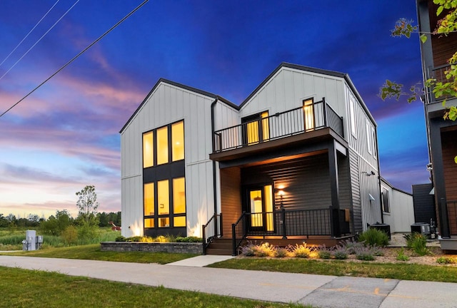 view of front of home featuring a yard and a balcony