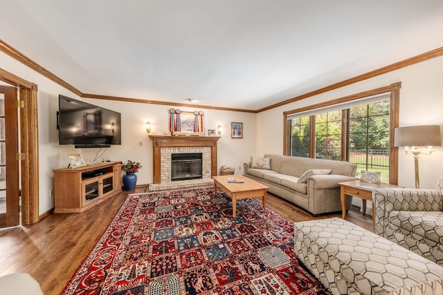 living room with hardwood / wood-style flooring, a fireplace, and ornamental molding