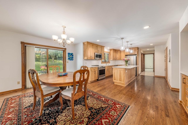 dining area with light hardwood / wood-style flooring and a chandelier