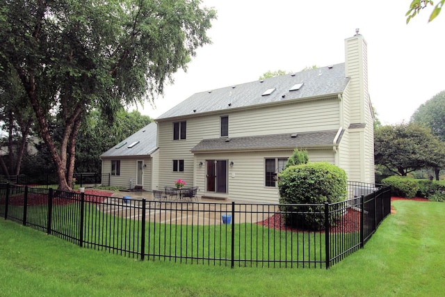 back of house featuring a lawn