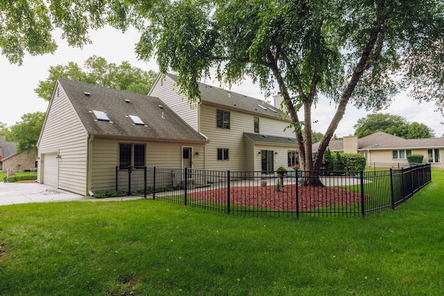 rear view of house with a garage and a yard