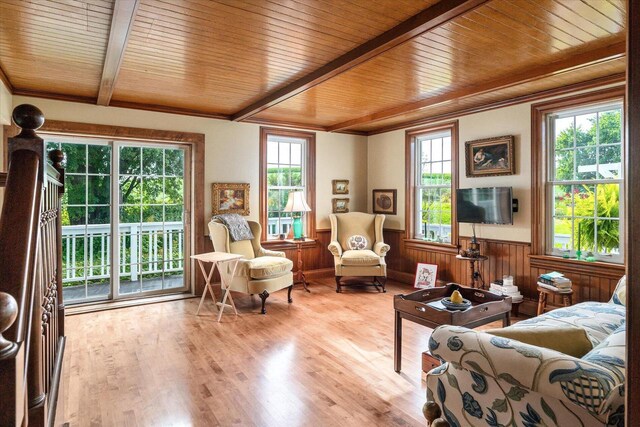 interior space featuring light wood-type flooring, wood walls, wood ceiling, and beam ceiling