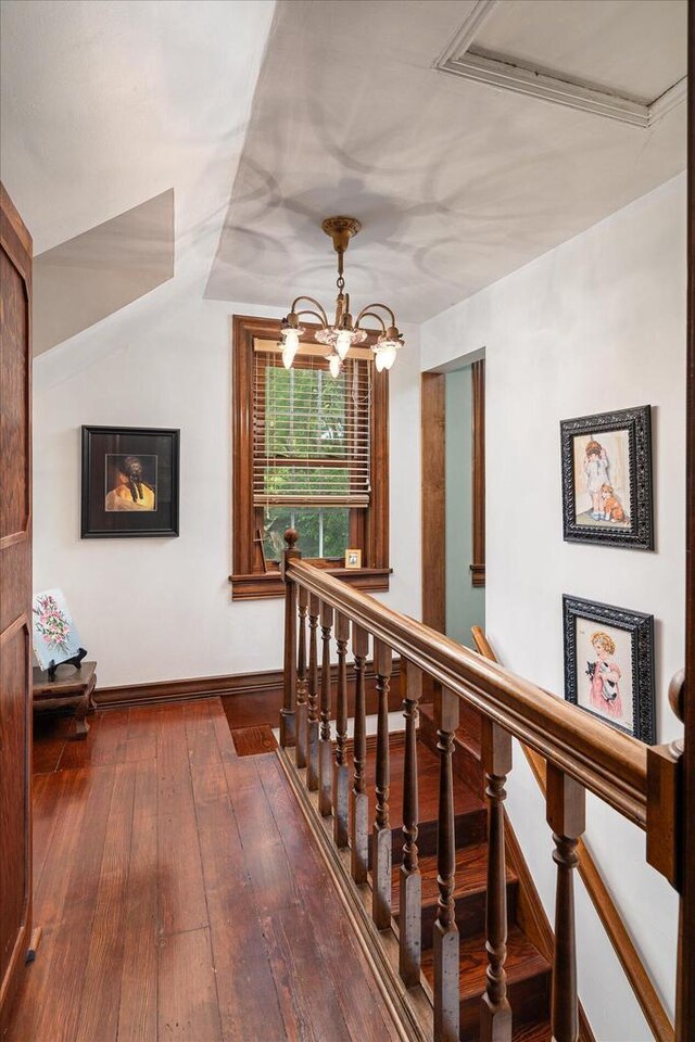 hallway with an inviting chandelier and wood-type flooring