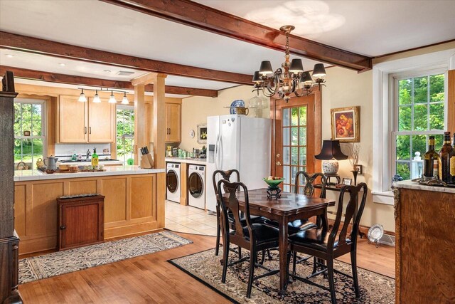 dining space with washing machine and clothes dryer, light hardwood / wood-style floors, plenty of natural light, and a chandelier