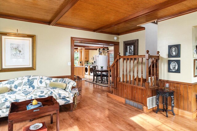 living room with beam ceiling, hardwood / wood-style flooring, a notable chandelier, independent washer and dryer, and wooden ceiling