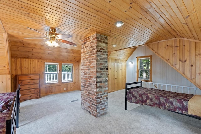 unfurnished bedroom featuring vaulted ceiling, light colored carpet, and wooden walls