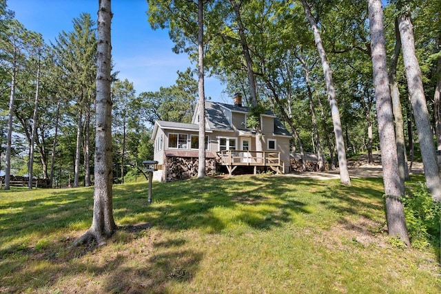 back of house with a wooden deck and a lawn