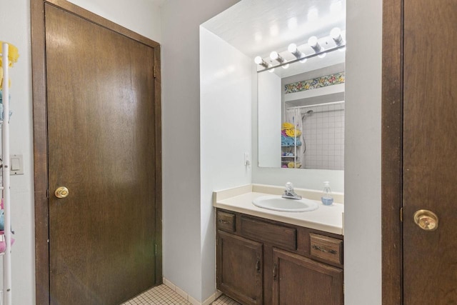 bathroom with tile patterned flooring, vanity, and walk in shower