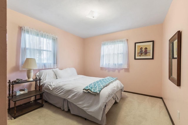 bedroom with multiple windows and light carpet