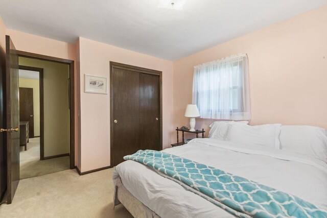 bedroom with light carpet and a closet