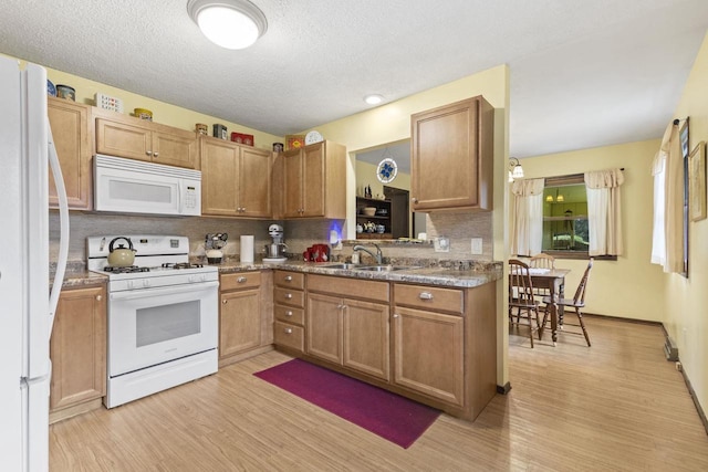 kitchen featuring sink, white appliances, tasteful backsplash, and light wood-type flooring