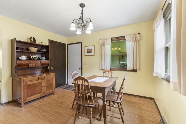 dining area featuring light hardwood / wood-style floors and a notable chandelier