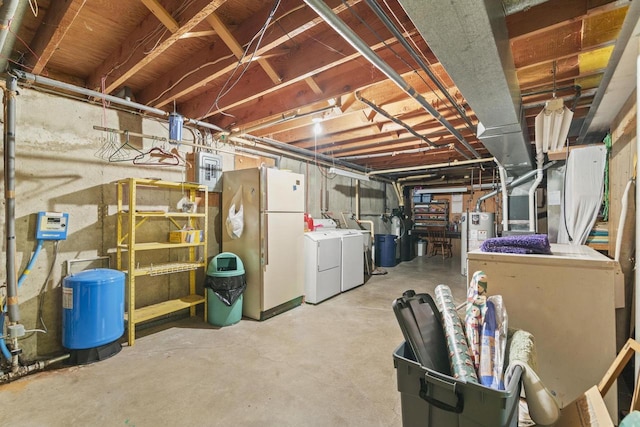 basement with independent washer and dryer, water heater, and white refrigerator