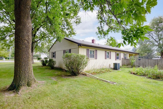 exterior space with cooling unit and a lawn