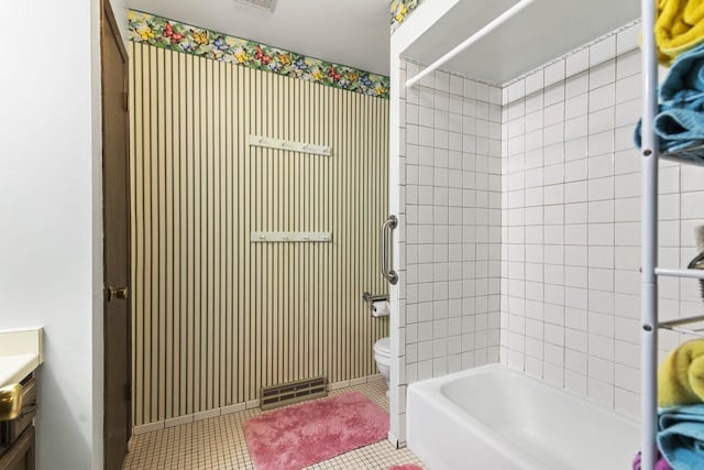 full bathroom with tiled shower / bath combo, vanity, tile patterned flooring, and toilet