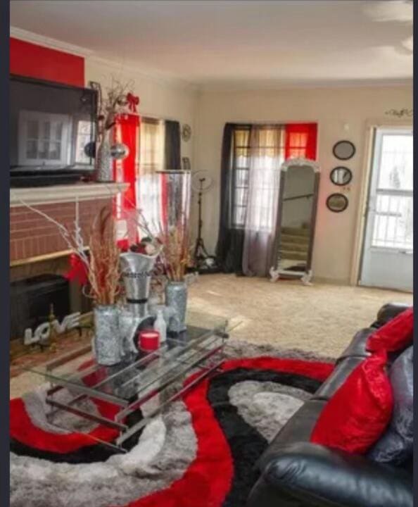 living room featuring carpet flooring and a brick fireplace