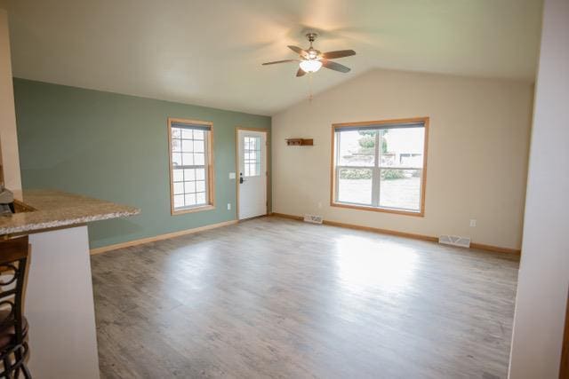 unfurnished living room with ceiling fan, wood-type flooring, and lofted ceiling