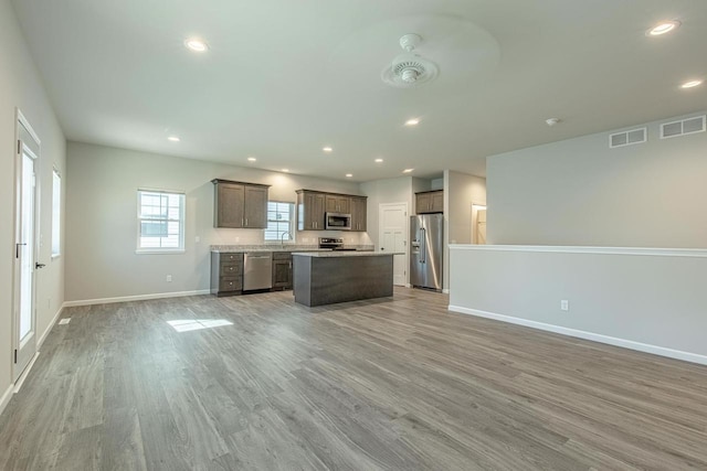 kitchen featuring light hardwood / wood-style flooring, sink, stainless steel appliances, and a center island