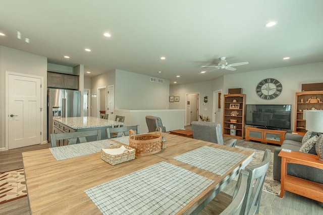 dining room with ceiling fan and light wood-type flooring