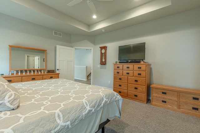 bedroom with carpet flooring, ceiling fan, and a raised ceiling